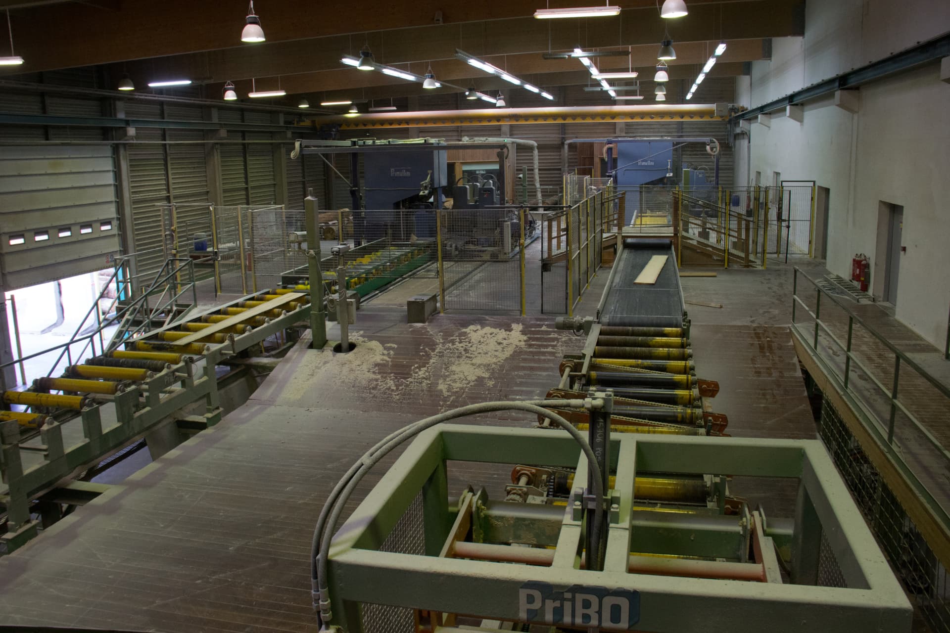 Pohled do výrobní haly pily LESS & TIMBER s dopravníky a linkou Primultini