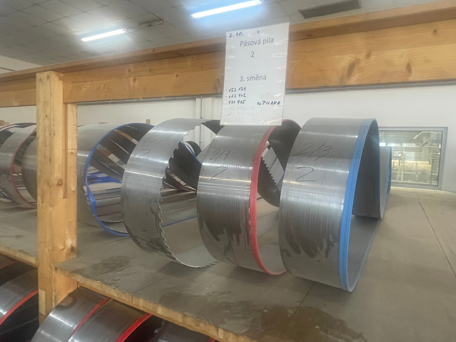 Připravené pilové pásy na regálu v brusírně pily LESS & TIMBER